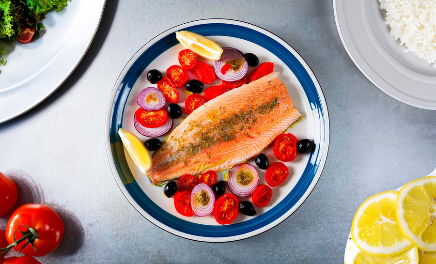 Filets de truite au four avec tomates, olives et rondelles d’oignon.