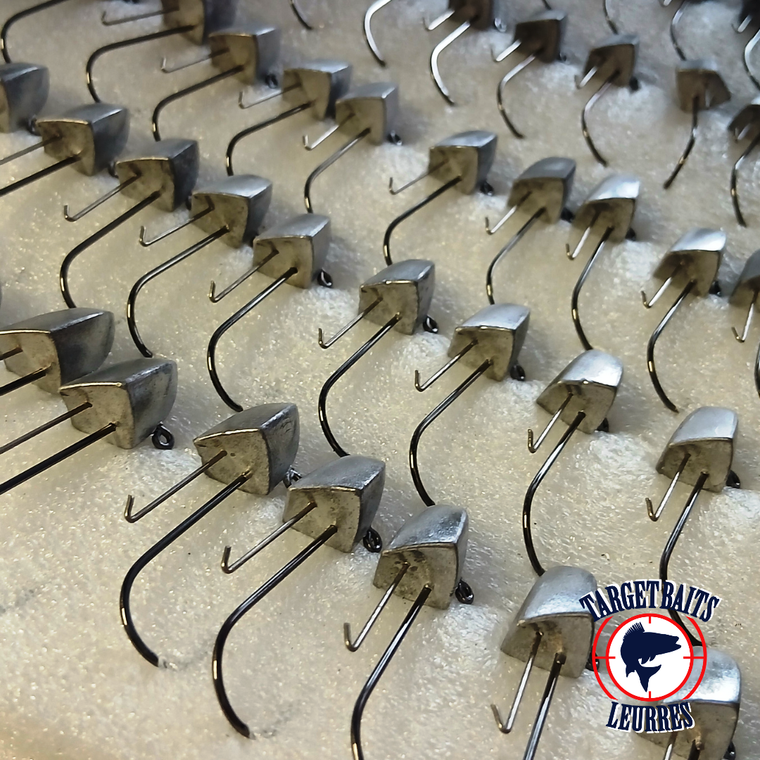 Têtes de jig Torpil Straight non peintes alignées dans l’atelier.